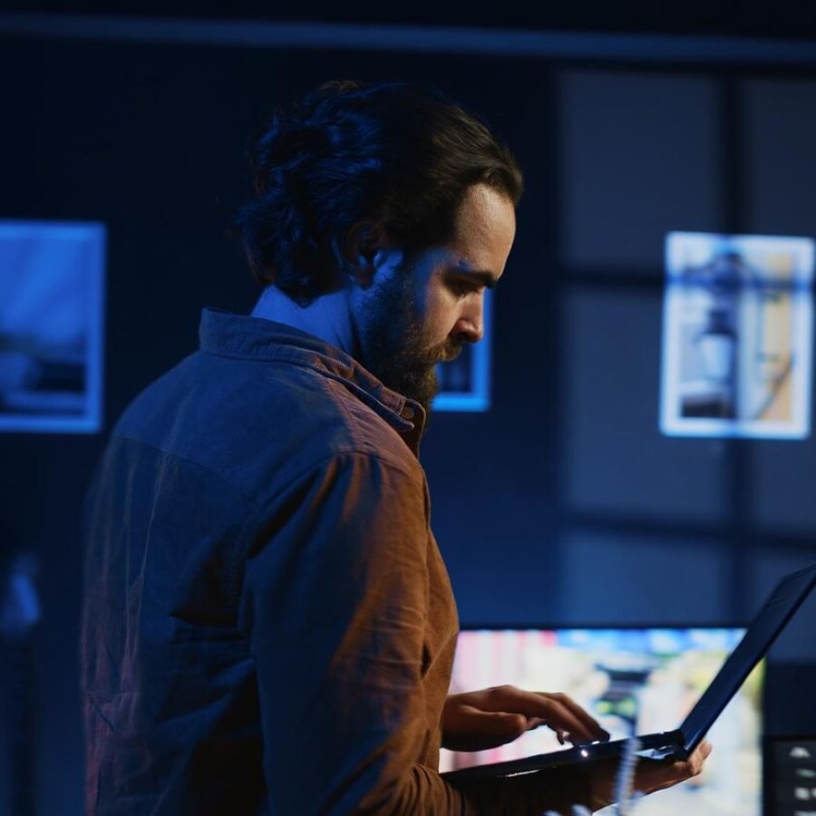 man-doing-it-support-job-from-home-walking-around-personal-office-with-laptop_482257-92977